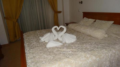 two white swans making a heart on a bed at Hotel Garden in Ohrid