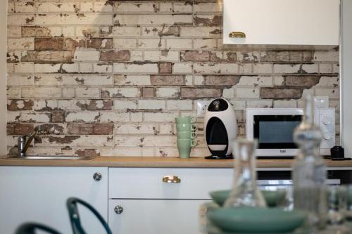 cocina con pared de ladrillo y encimera en Alojamientos Teatro, en Porcuna