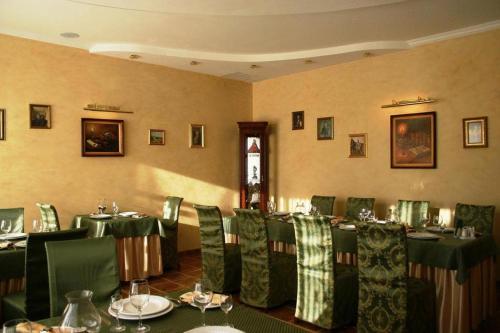 a dining room with green tables and chairs at Sudarushka Hotel in Krasnodar