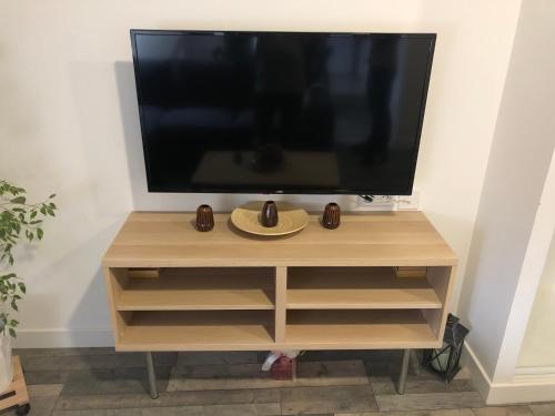 a television on a wooden stand with a plate on it at Casa SM in Mennecy