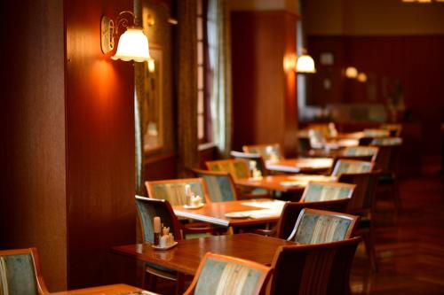a row of wooden tables and chairs in a restaurant at Hotel JAL City Aomori in Aomori