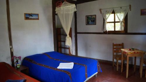 um quarto com uma cama, uma mesa e uma janela em Finca Lindos Ojos em Estelí