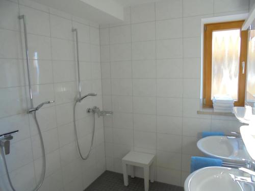 een witte badkamer met 2 wastafels en een douche bij Ferienwohnung Haus Elisabeth, Roßfeldalm in Berchtesgaden