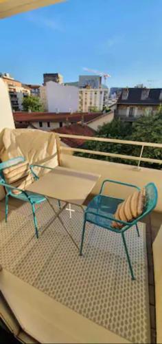 a balcony with a table and chairs on a roof at Tichnich Appartement - 2 bedrooms - 1 min away from train station in Annemasse