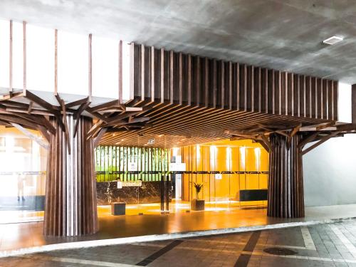a lobby with large wooden pillars in a building at Cat City Mediterranean Theme City&Pool View Homestay 貓城地中海主題城市泳池風景民宿 in Kuching