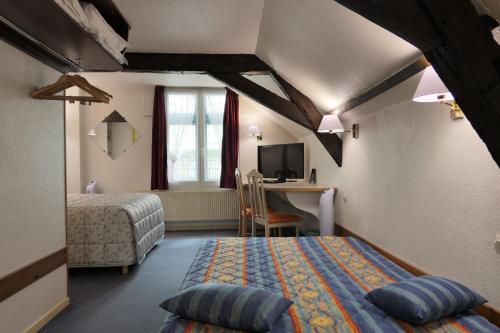 Un dormitorio con 2 camas y un escritorio en una habitación. en Hôtel Les Trois Luppars, en Arras