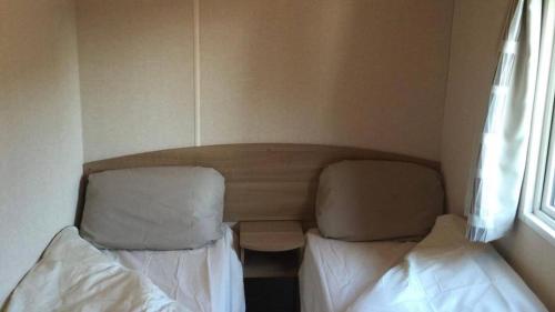 a small room with two beds and a window at Turlin Valley in Poole