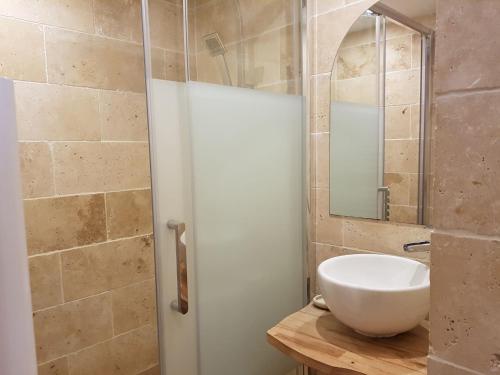 Un baño con un lavabo blanco y un espejo. en INTRAMUROS Charmant 30m2 rénové, en Saint-Malo