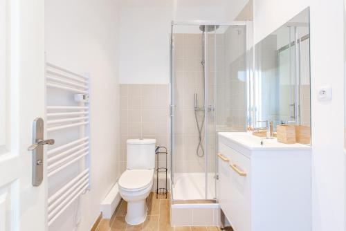 une salle de bain blanche avec toilettes et douche dans l'établissement Le Cosy Blancarde -Appartement 1 chambre 4 pers- Clim Parking, à Marseille