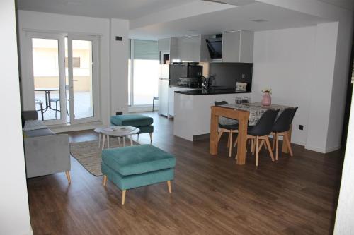 a living room and kitchen with a table and chairs at Cabeço das Fráguas - apartamento centro cidade da Guarda in Guarda