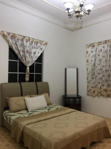 a bedroom with a bed and a window with curtains at Seribu 1 Homestay 3 Rooms in Kundasang