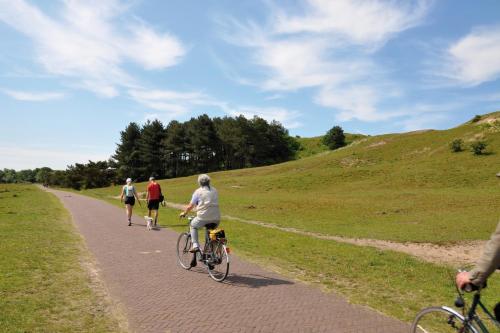 a group of people riding bikes down a road at Hotel De Boei in Egmond aan Zee