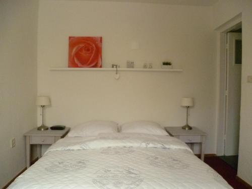 a bedroom with a bed with two tables and a red painting at Hotel Pension Oranje in Valkenburg