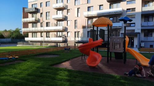 einen Spielplatz vor einem Gebäude mit Rutsche in der Unterkunft Grey Residence Apartament in Târgu Mureș