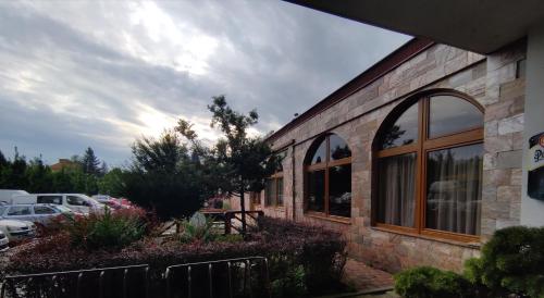 a brick building with windows in a parking lot at Hotel Apollo in Valašské Meziříčí