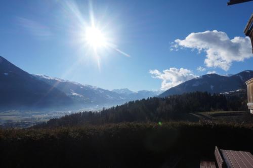 a sun shining over a valley with mountains at Gasthaus Goglhof in Fügenberg