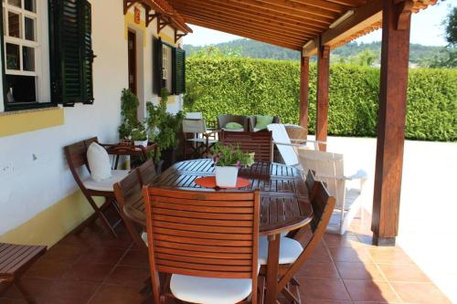 a wooden table and chairs on a patio at CORVITINHO in Guimarães