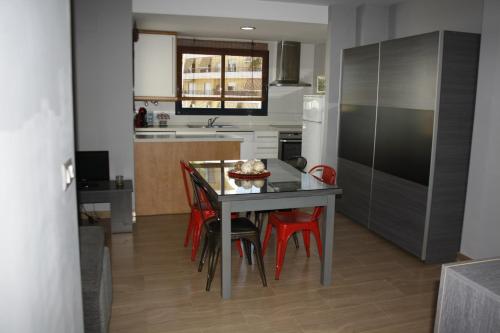 
a kitchen with a table and chairs and a refrigerator at Camalavi in Moraira
