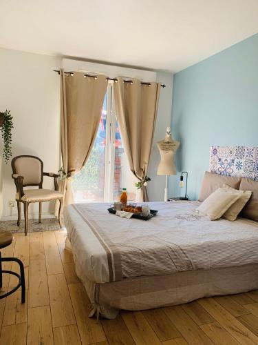 une chambre avec un lit, une chaise et une fenêtre dans l'établissement Bed and Breakfast Luxe Paris, à Courbevoie