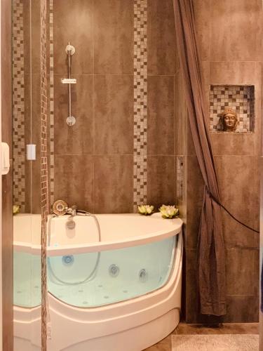 une salle de bain avec baignoire et douche dans l'établissement Bed and Breakfast Luxe Paris, à Courbevoie