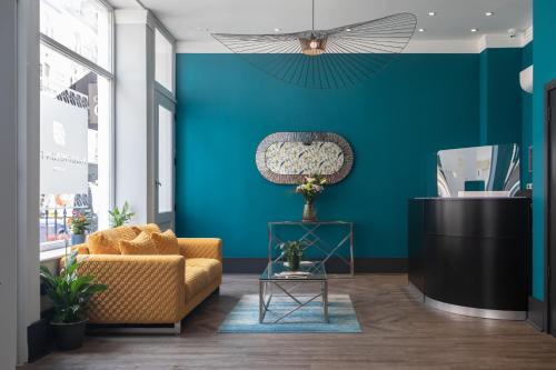 a living room with a couch and a blue wall at Paddington Park Hotel in London