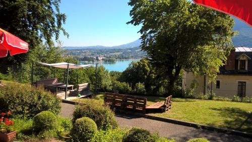 un parc avec bancs et vue sur un lac dans l'établissement Auberge de Jeunesse HI Annecy, à Annecy