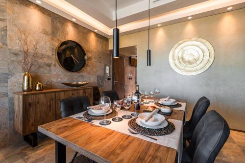 une salle à manger avec une table en bois et des chaises noires dans l'établissement THE miniPENTHOUSE terrace & SPA, à Paço de Arcos
