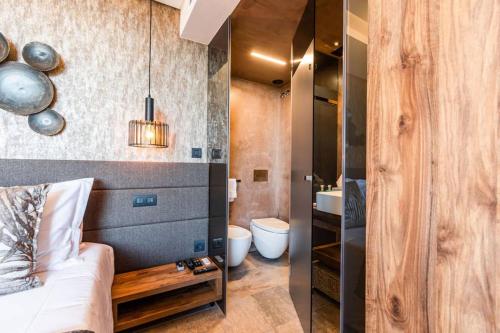 a room with a bed and a bathroom with a sink at THE miniPENTHOUSE terrace & SPA in Paço de Arcos