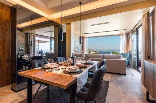 a dining room with a table and chairs and a living room at THE miniPENTHOUSE terrace & SPA in Paço de Arcos