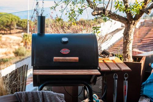 a grill sitting on top of a wooden table at THE miniPENTHOUSE terrace & SPA in Paço de Arcos