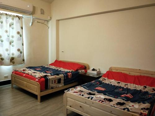 two twin beds in a room with a window at Wish enjoy happy Homestay in Ligang