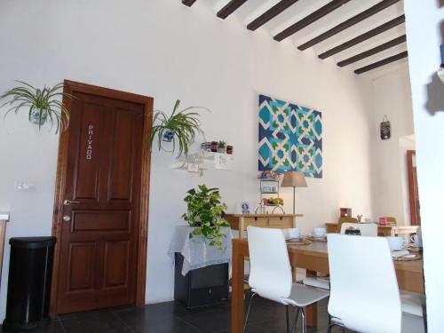 een eetkamer met een tafel en een houten deur bij Bed & Breakfast Casa El Sueño in Arcos de la Frontera