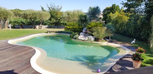 - une piscine dans une cour avec une terrasse en bois dans l'établissement LE CLOS DES VIGNES, à Junas