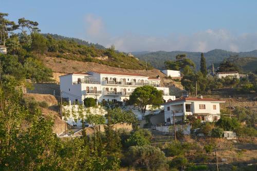 a large white building on a hill at Ikaros Star Hotel in Gialiskari