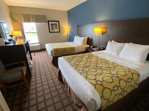 a hotel room with two beds and a chair at Baymont by Wyndham Morton in Morton