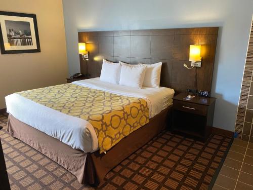 a hotel room with a large bed and two lamps at Baymont by Wyndham Morton in Morton