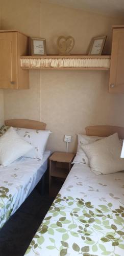 two beds sitting next to each other in a room at Park Home at Golden Sands Holiday Park N.Wales in Rhyl