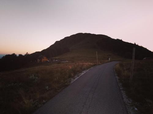 an empty road with a mountain in the background at Vikendica Vila Despotovic in Kopaonik