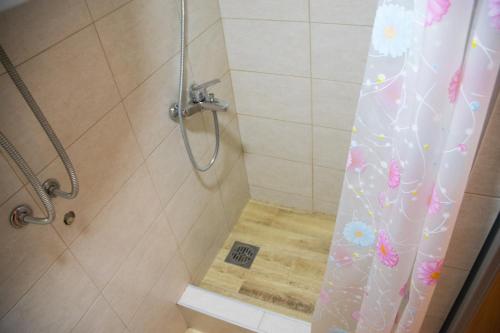 La salle de bains est pourvue d'une douche avec rideau de douche. dans l'établissement Double Decker Apartment, à Belgrade