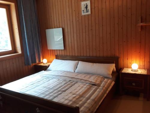 ハイリゲンブルートにあるAppartement Gorgasser im Berghaus Glocknerのベッドルーム1室(ベッド1台、2つのテーブルに照明付)