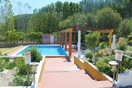 une piscine dans un jardin avec un chemin menant à celle-ci dans l'établissement Casal do Varatojo, à Alcobaça