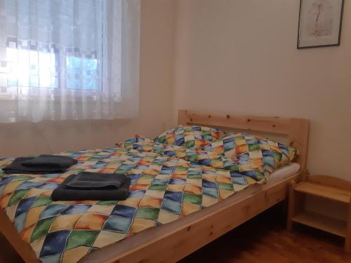 a bed with a colorful quilt on it in a bedroom at Zacisze in Kołczewo