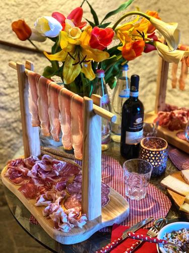 a table with a plate of meat and a vase of flowers at Il Roccolino in Valsecca