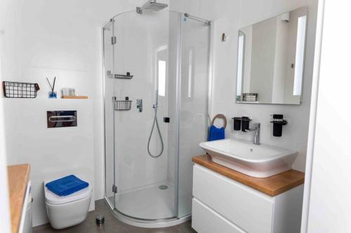 biała łazienka z prysznicem i umywalką w obiekcie REMAR - Apartamenty nad Jeziorem Necko w mieście Augustów