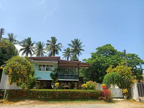 a house with a porch and flowers in front of it at Boons Bungalow Ban Krut in Ban Krut