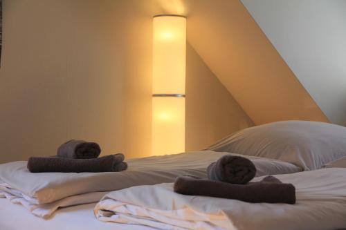 a bed with towels on top of it with a lamp at ruhige gemütliche 2Z-Whg in S-West in Stuttgart