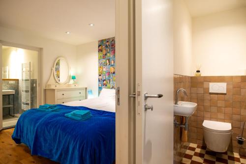 グルペンにあるDe Auw Sjoekelaatfabriekのベッドのある寝室と洗面台のある浴室