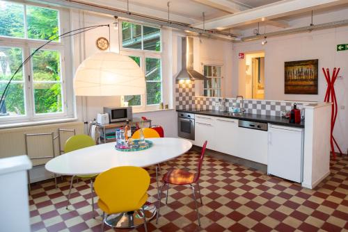 a kitchen with a table and chairs in a room at De Auw Sjoekelaatfabriek in Gulpen