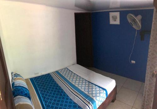 a small bed in a room with a blue wall at Nice Place Hostel in Fortuna
