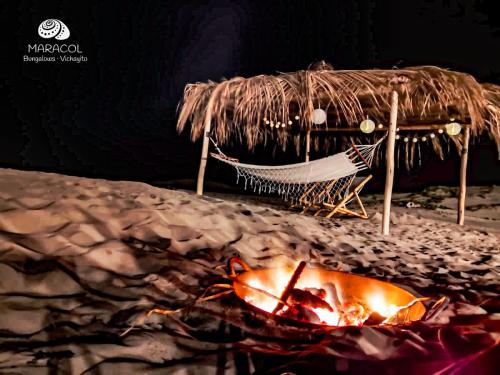 a hammock and a campfire on the beach at night at Maracol Bungalows Vichayito in Vichayito